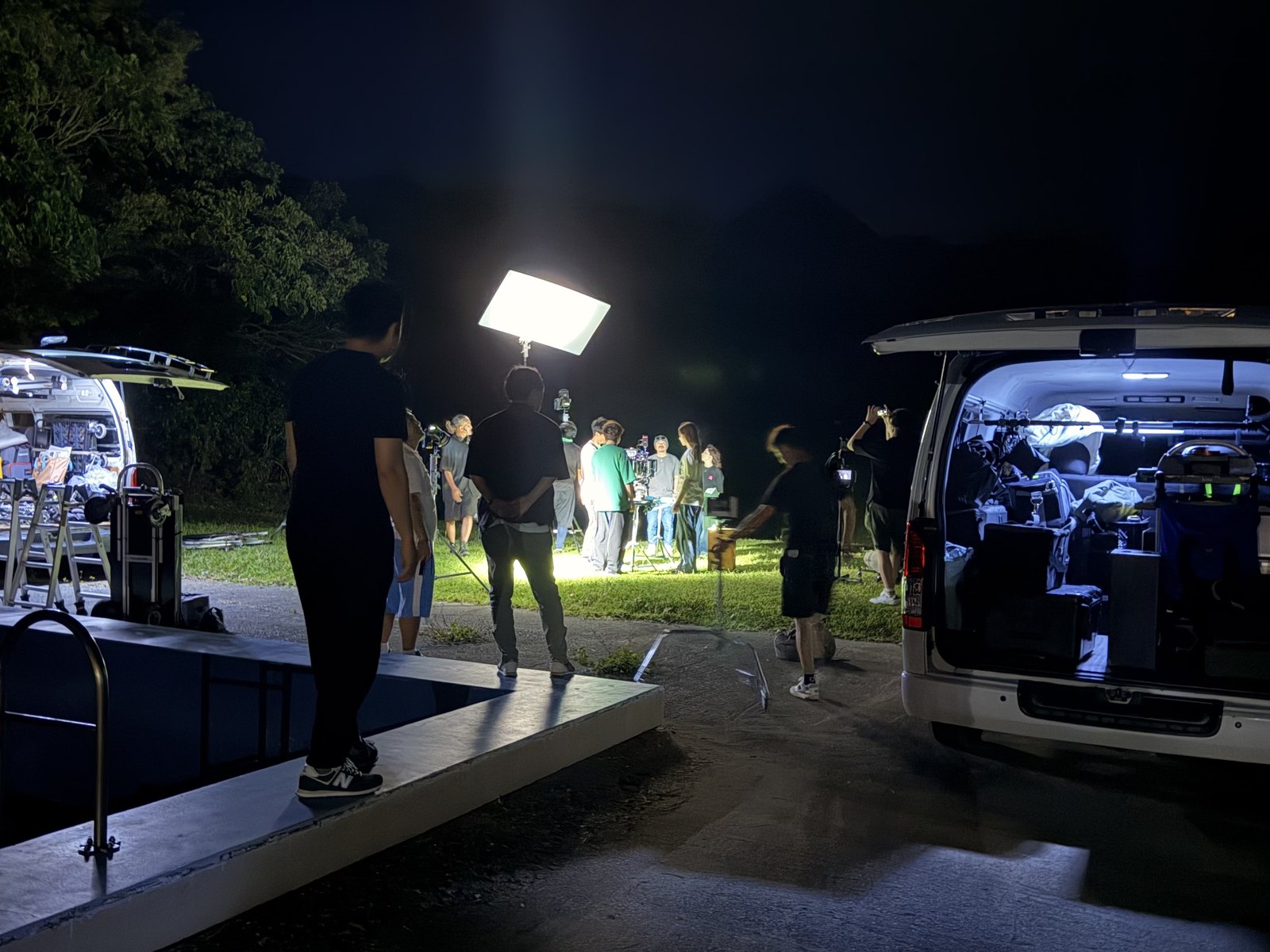 沖縄での夜間ロケの現場。照明・機材車・スタッフが稼働している様子